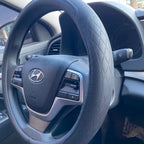 capa de volante em couro de napa na cor preta, sendo utilizada no volante do carro