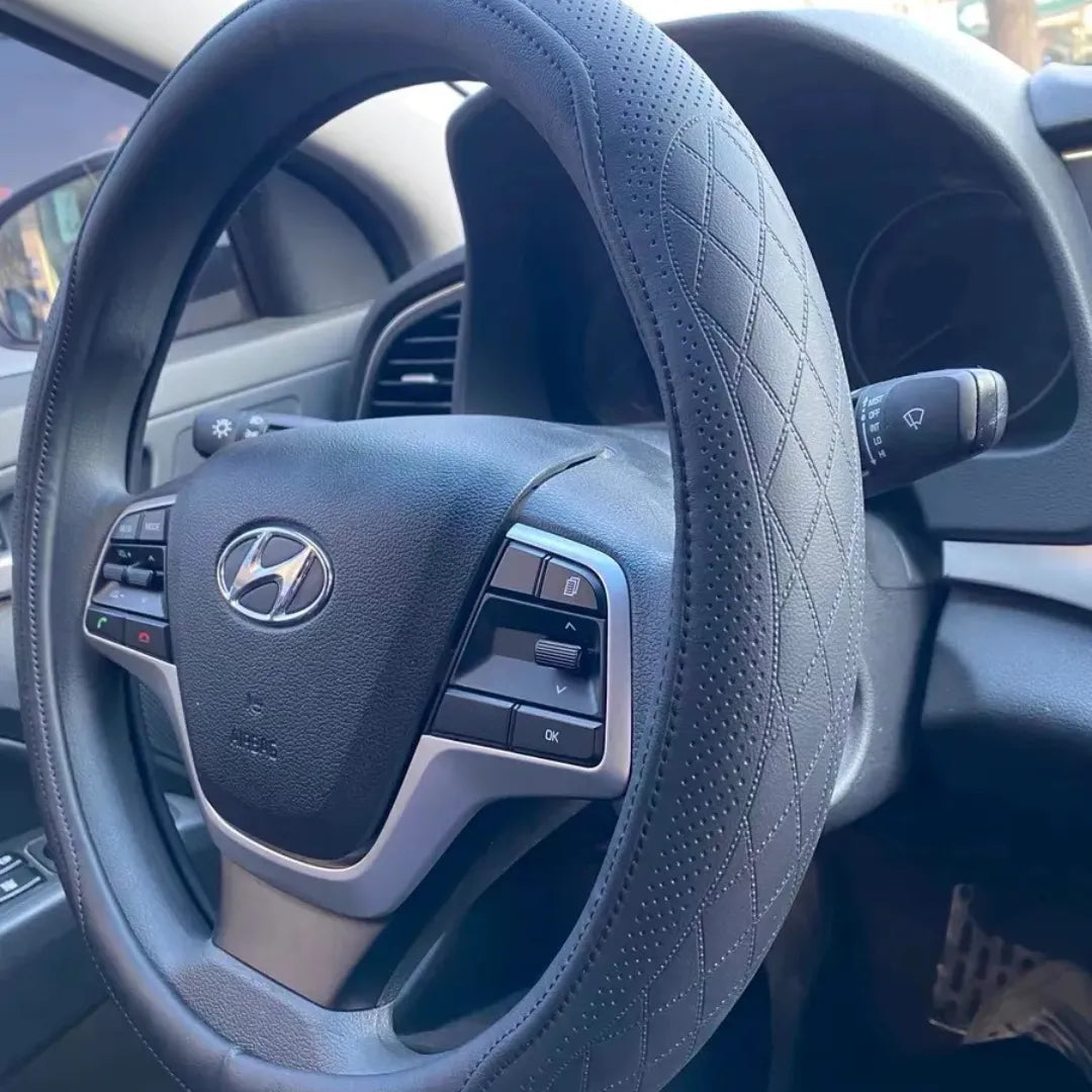 capa de volante em couro de napa na cor preta, sendo utilizada no volante do carro