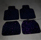 Quatro tapetes de carro com LED roxa ligada, mostrando design e iluminação fora do carro